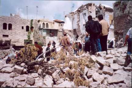 Palestinians survey the ruins of the Shakaa Soap factory